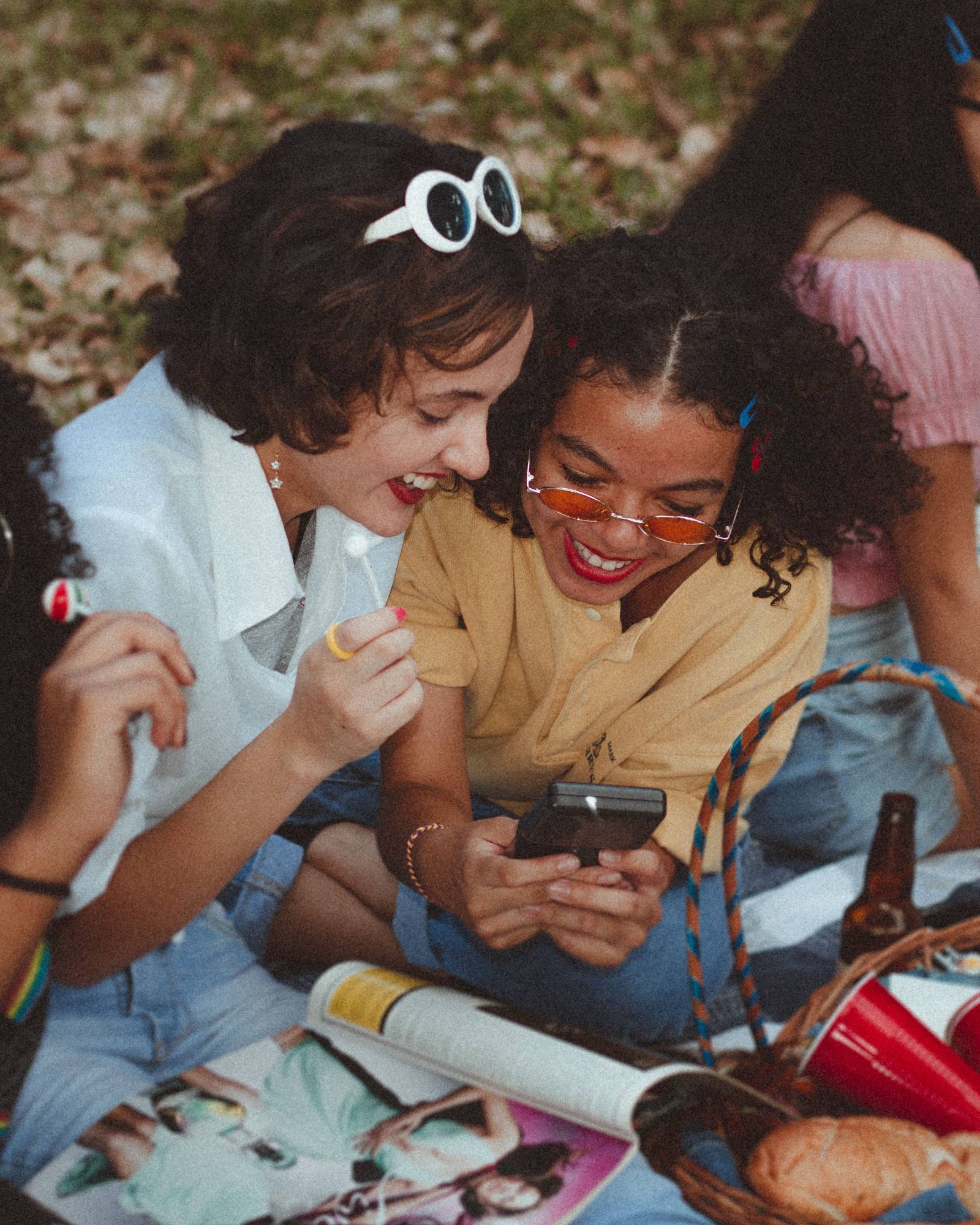 Two friends laughing together at a picnic