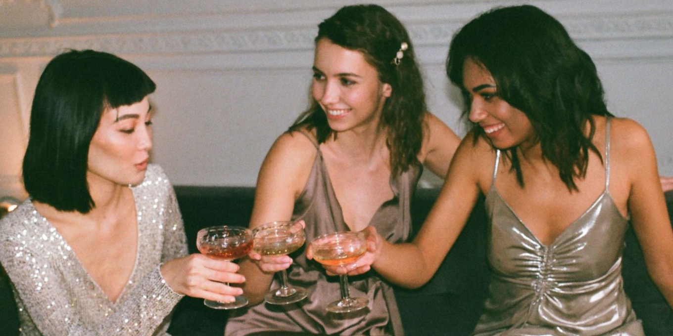 Three friends toasting together on a sofa