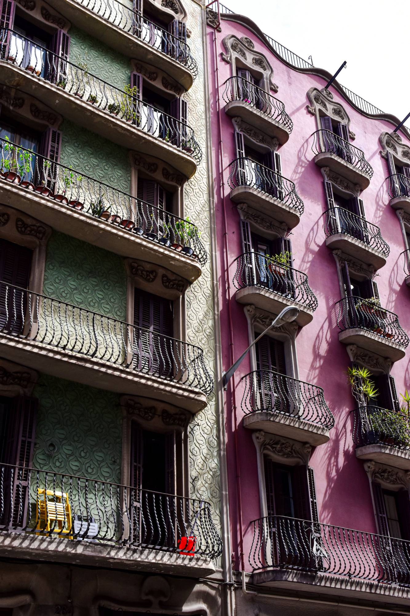 Colorful apartment buildings with wrought-iron balconies and plants